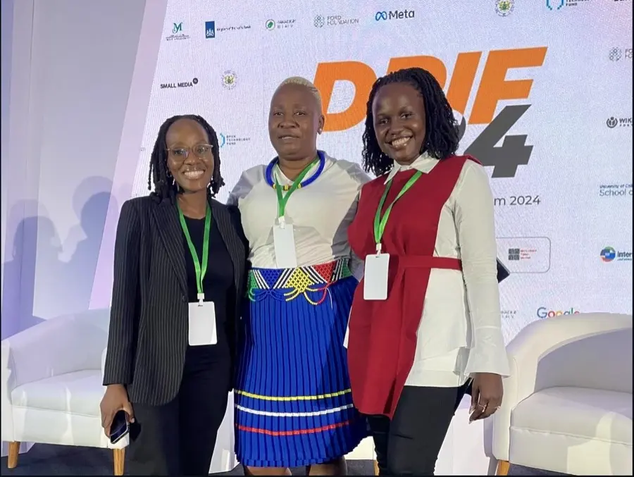 Three Resilience Technologies delegates at DRIF24, photographed in front of the forum banner.